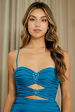 Woman wearing a blue strapless dress with embellishments against a neutral background