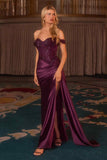 Woman in a purple evening gown standing in an elegant room with patterned carpet.