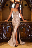Woman in a silver evening gown standing in an ornate room.